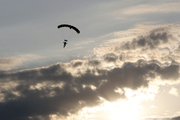 Parachutist  flying in the blue evening sky.