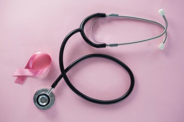 Overhead view of stethoscope by Breast Cancer Awareness ribbon