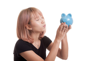 Young Asian woman kiss  a pink coin bank.