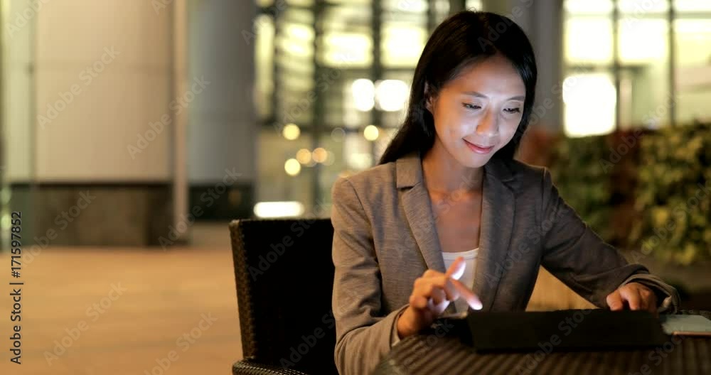 Poster Business woman working on tablet computer at night