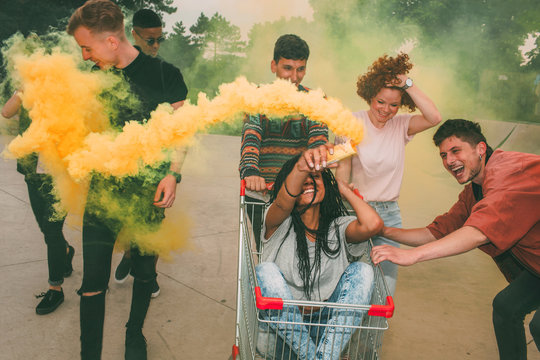 Teenagers having fun with a shopping cart and smoke grenade