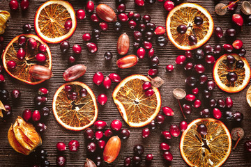 Autumn still life with orange caramel and cranberries on wood