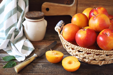 Yellow and red plums in wicker basket