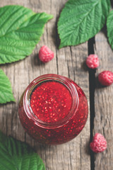 Jar with homemade raspberry jam. Ripe Berries and Leaves. Top view