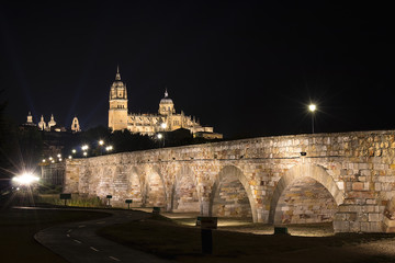 Fototapeta na wymiar Night view of Salamanca Old and New Cathedrals from Roman Bridge over Tormes River, Community of Castile and Leon, Spain. 