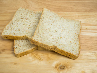 Three slice whole wheat bread on wooden table