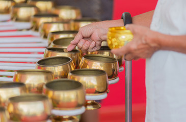 The hand of an elderly woman Inserting a coin into a brass case. Which is faith and faith One of the people in some Asian countries.