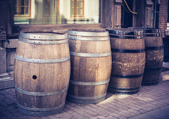 Set of old empty beer barrels in street outside. Toned