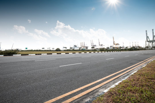 empty asphalt road with cranes in sunny day