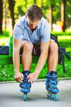 Young skater tying laces on his inline roller skates.