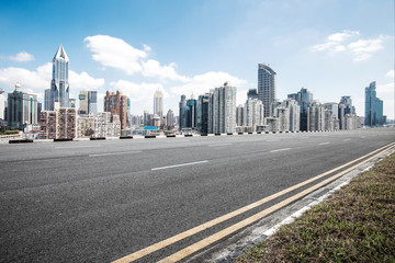 Fototapeta na wymiar empty asphalt road with cityscape of modern city