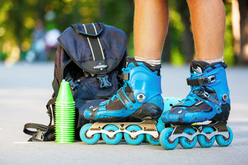 Closeup photo of legs in blue inline skates standing.