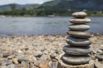Natural stone stack over blurred river view background, outdoor day light