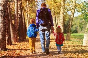 father with little son and daughter going to school