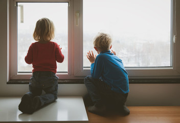 little girl and boy looking through the window