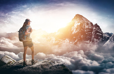 Bergsteigerin steht auf Berggipfel und genießt die Aussicht - obrazy, fototapety, plakaty