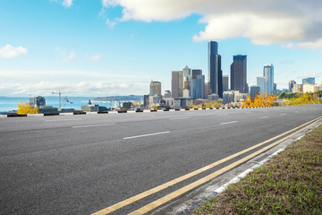 empty asphalt road with cityscape of modern city in blue sky