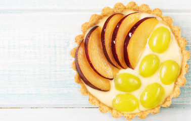 Tart with custard and berries, raspberry, light blue background, horizontal, top view, soft focus