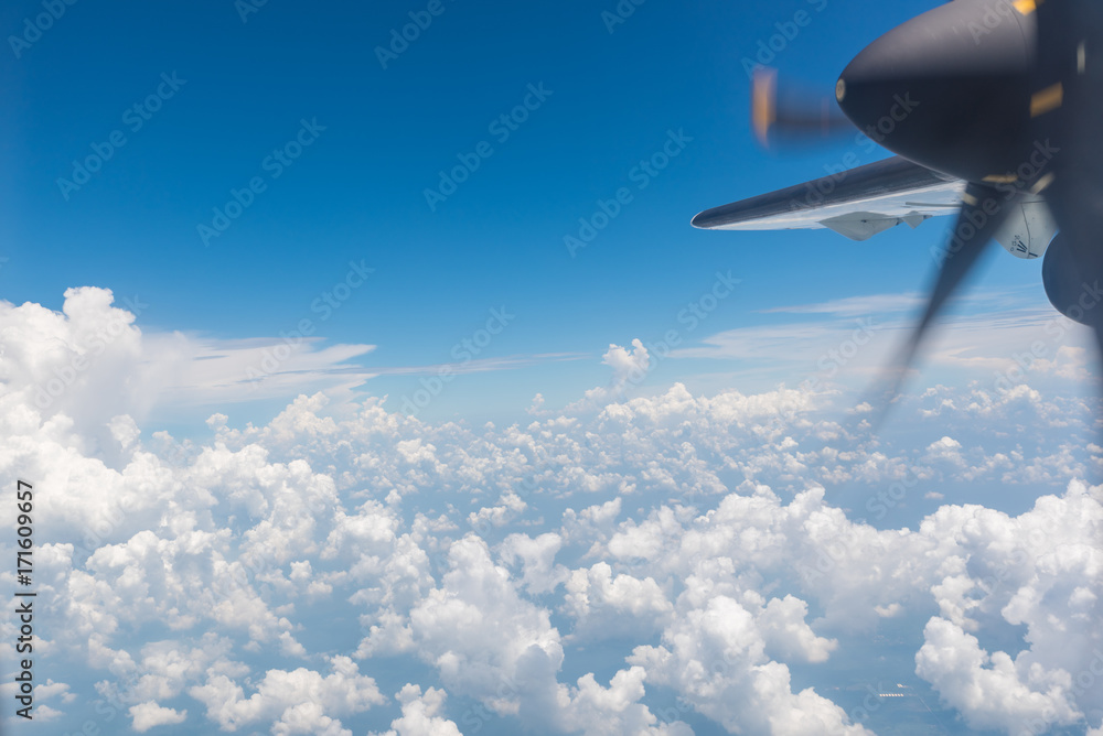 Wall mural clouds and sky with wing of an airplane.