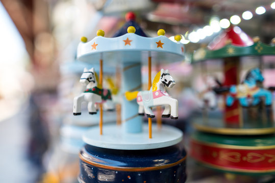Little toy, souvenir- flying horse carousel with blurred background on the counter of the store