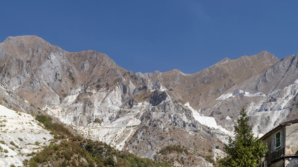 Fototapeta na wymiar The Apuan Alps and the famous marble quarries viewed from the village of Colonnata, Carrara, Italy, on a sunny day