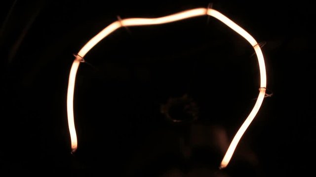 Close-up of a yellow tungsten filament. Smooth increase and decrease in power.
