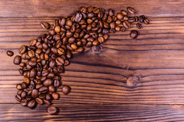 Pile of the roasted coffee beans on wooden table. Top view
