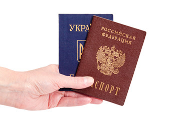 Russian and Ukrainian passports in the hand on the white background