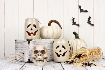 Rustic white Halloween decor still life against a white wood background