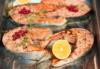 Salmon steak with lemon in a metal bowl