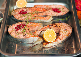 Salmon steak with lemon in a metal bowl