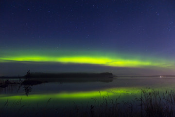 Aurora australis rich colors above lake in Finland