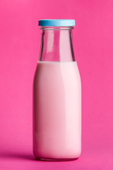 Pink milk bottle on pink background.