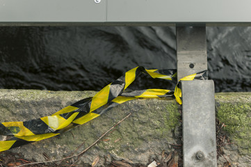 Yellow industrial ribbon tied to a metal railing