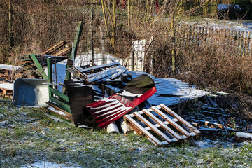 Müllhaufen mit Holz und Kunststoff im Garten