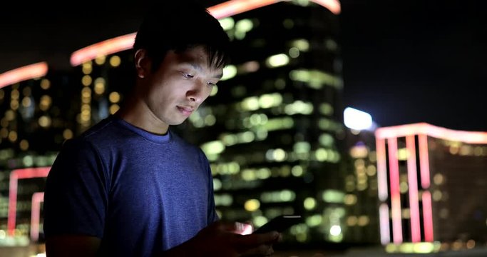Young man working on cellphone at night