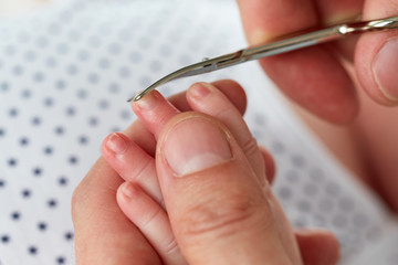 Close up of dad cutting son's nails