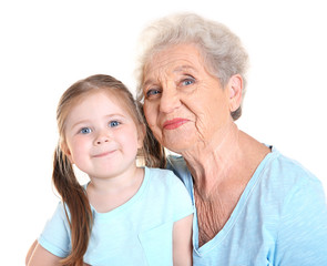 Cute little girl with her grandmother on white background
