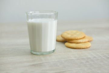 MILK GLASS AND CRACKERS
A glass of milk with pile of crackers on the wood top table. 
