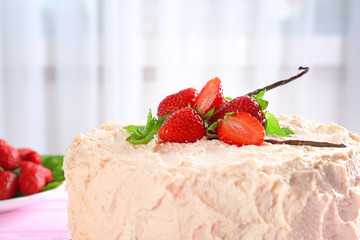 Delicious vanilla cake with strawberries on table