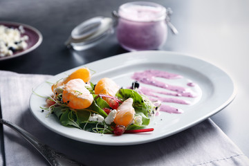Delicious superfood salad served with pink sauce on white ceramic plate in kitchen