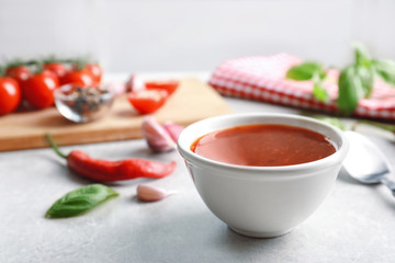 Composition with chili sauce in bowl on table