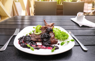 Delicious ribs served with sauce and salad on dinner table