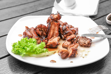 Delicious ribs served with salad on dinner table