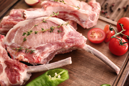 Raw ribs with vegetables and seasoning on kitchen table