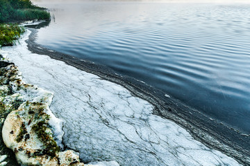 Pollution foam on the shore of a lake in Quebec