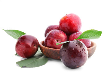 Bowl with fresh ripe plums on white background