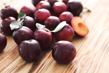 Fresh ripe plums on wooden table, closeup