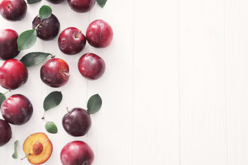 Naklejka na ściany i meble Fresh ripe plums on white background