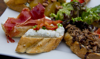 Assorted rustic Spanish tapas on wooden board—traditional snack selection perfect for culinary editorials and Mediterranean food branding.